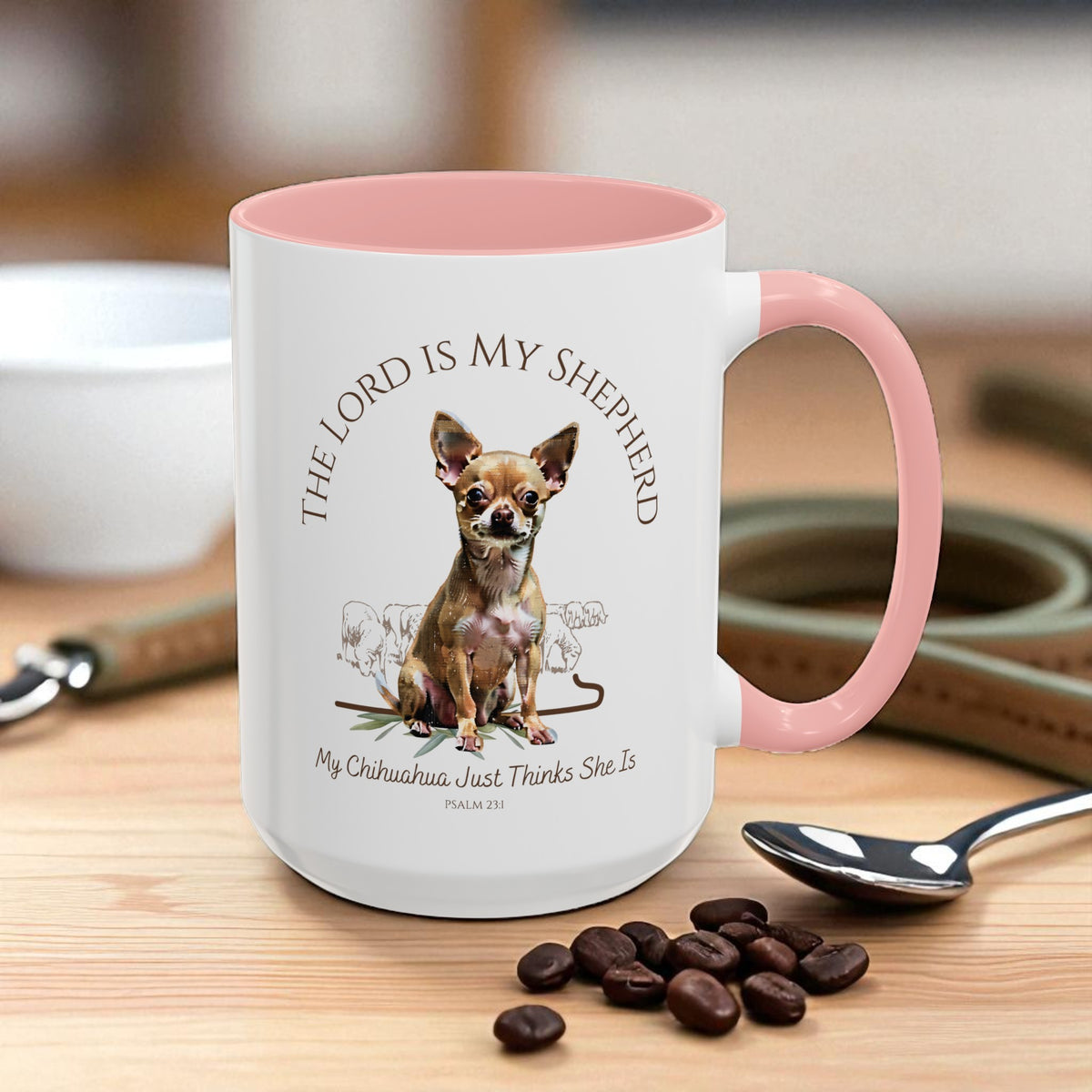 Mug with pink interior and handle, featuring a dog illustration and text on a wooden surface with coffee beans and a spoon.
