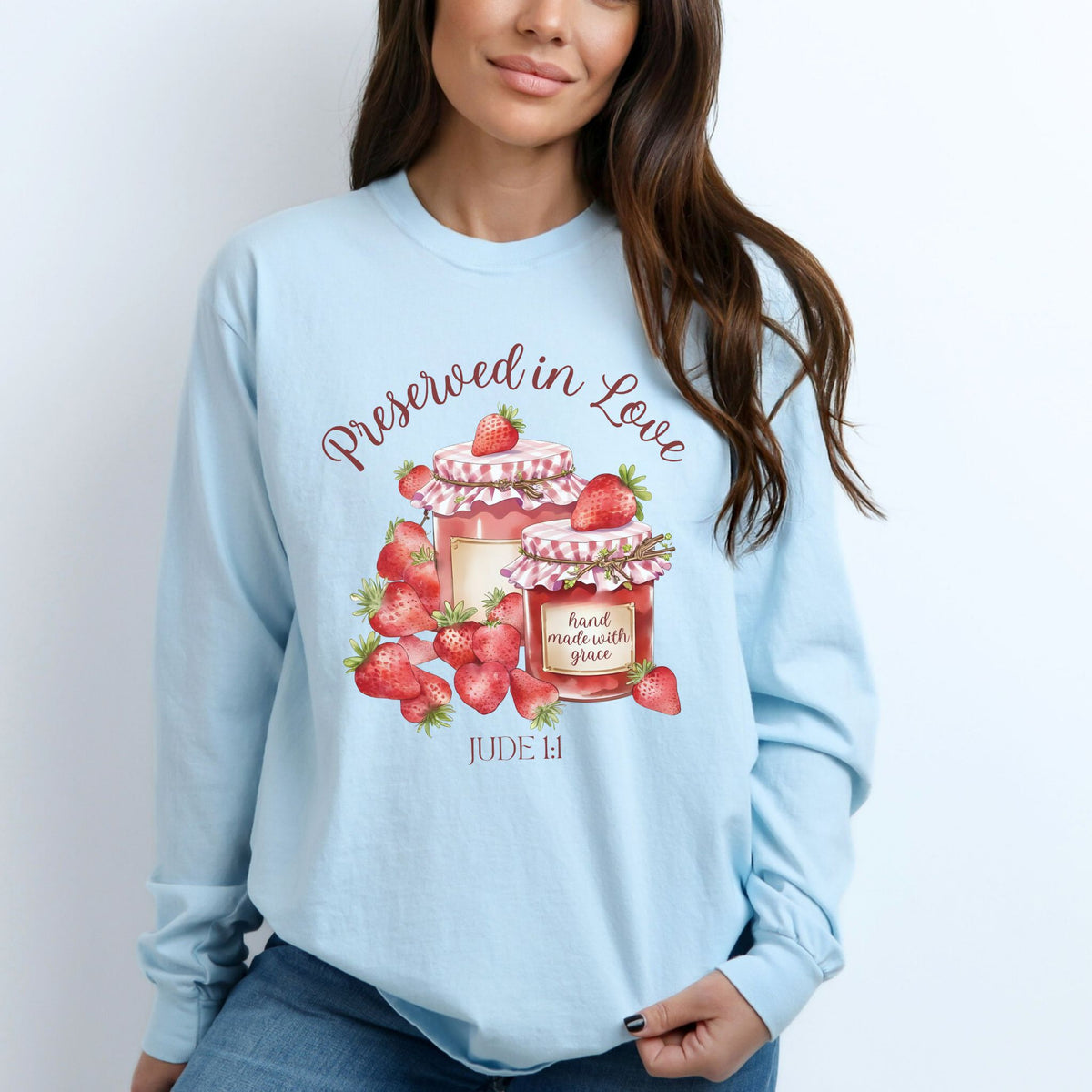 Light blue sweatshirt with strawberry-themed design and text, worn by a person.