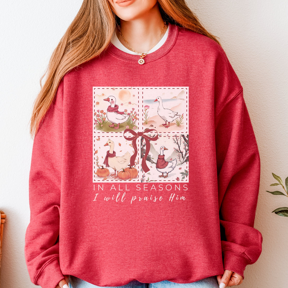 Red sweatshirt with a graphic design and text worn by a person