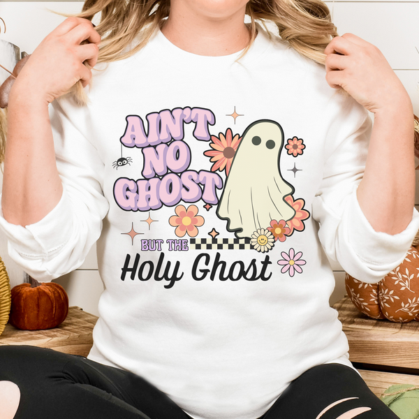 Person wearing a white sweatshirt with a ghost graphic and text in a casual setting.