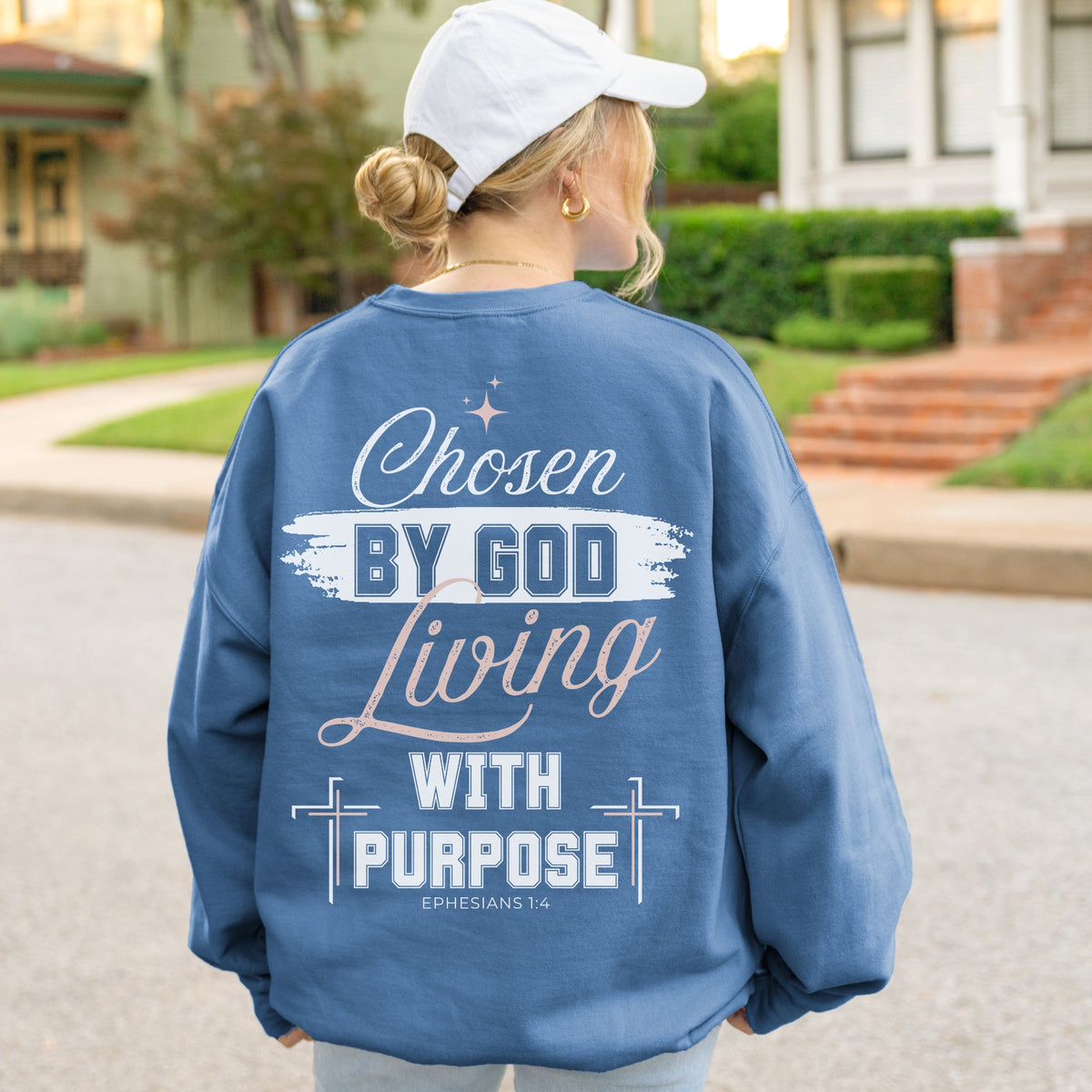 Person wearing a blue sweatshirt with a motivational quote outdoors.