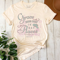 Beige t-shirt with motivational quote on a wooden surface with plants