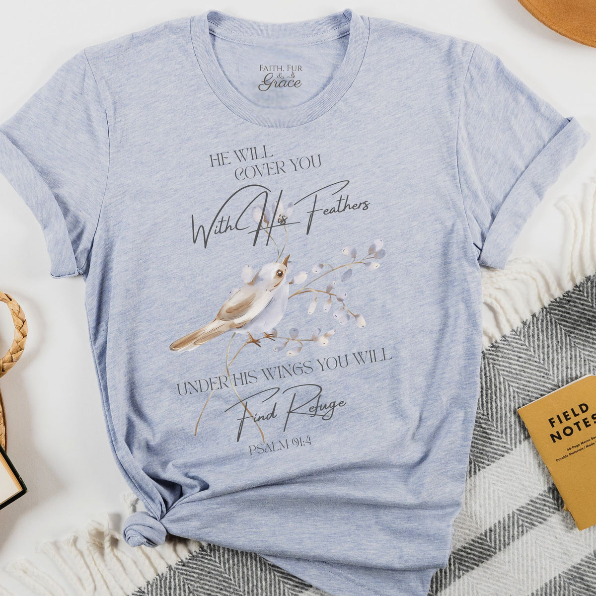 Blue t-shirt with a bird graphic and text on a white surface