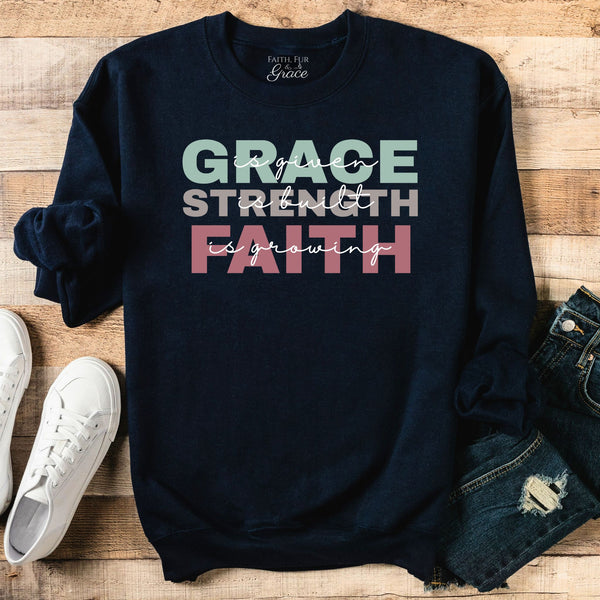Navy sweatshirt with motivational quote on a wooden surface with shoes and jeans.