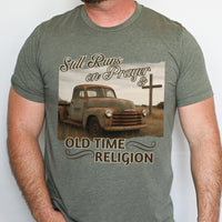 Green t-shirt with an old truck and cross graphic and text 'Still Runs on Prayer & Old Time Religion'.