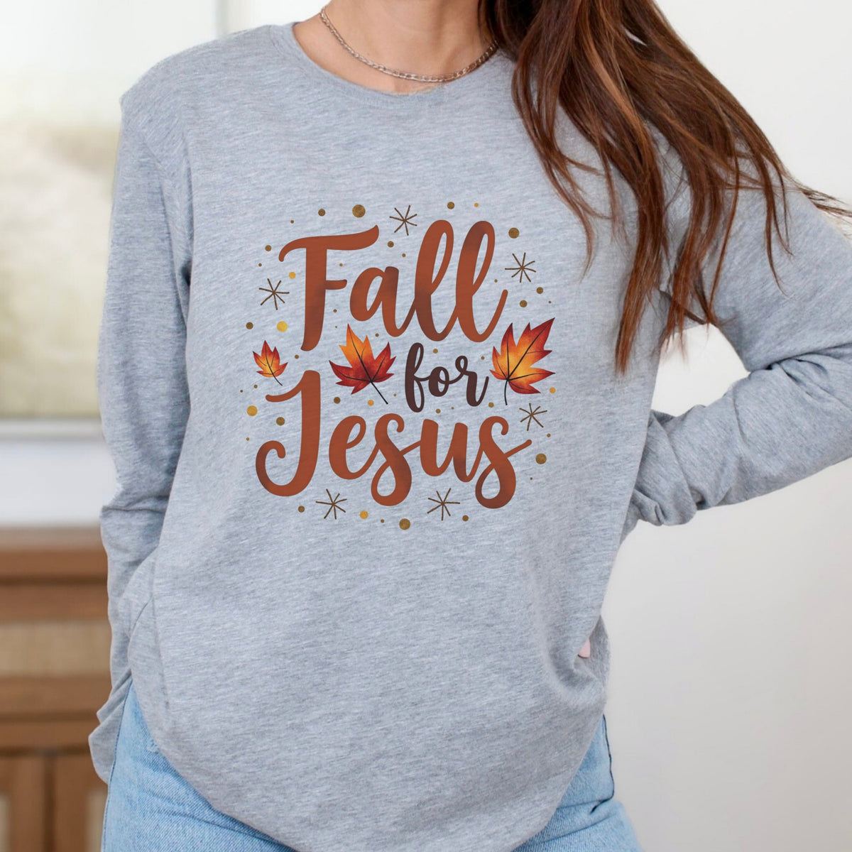 Gray long sleeve tee with 'Fall for Jesus' text and autumn leaves worn by a person.