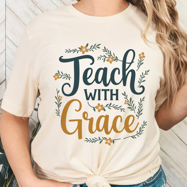 Person wearing a white t-shirt with 'Teach with Grace' text and floral designs.