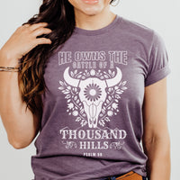 Person wearing a purple t-shirt with a graphic design and text.