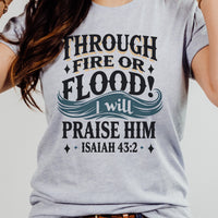 Gray t-shirt with motivational quote 'Through fire or flood I will praise Him' from Isaiah 43:2 on a plain background