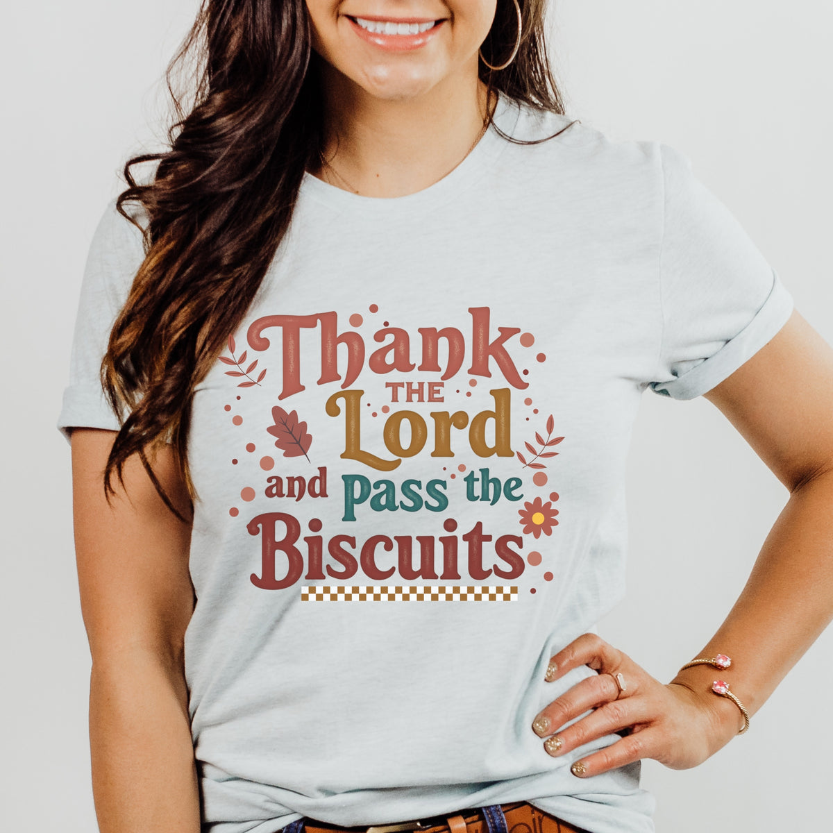Person wearing a t-shirt with 'Thank the Lord and Pass the Biscuits' text on a plain background