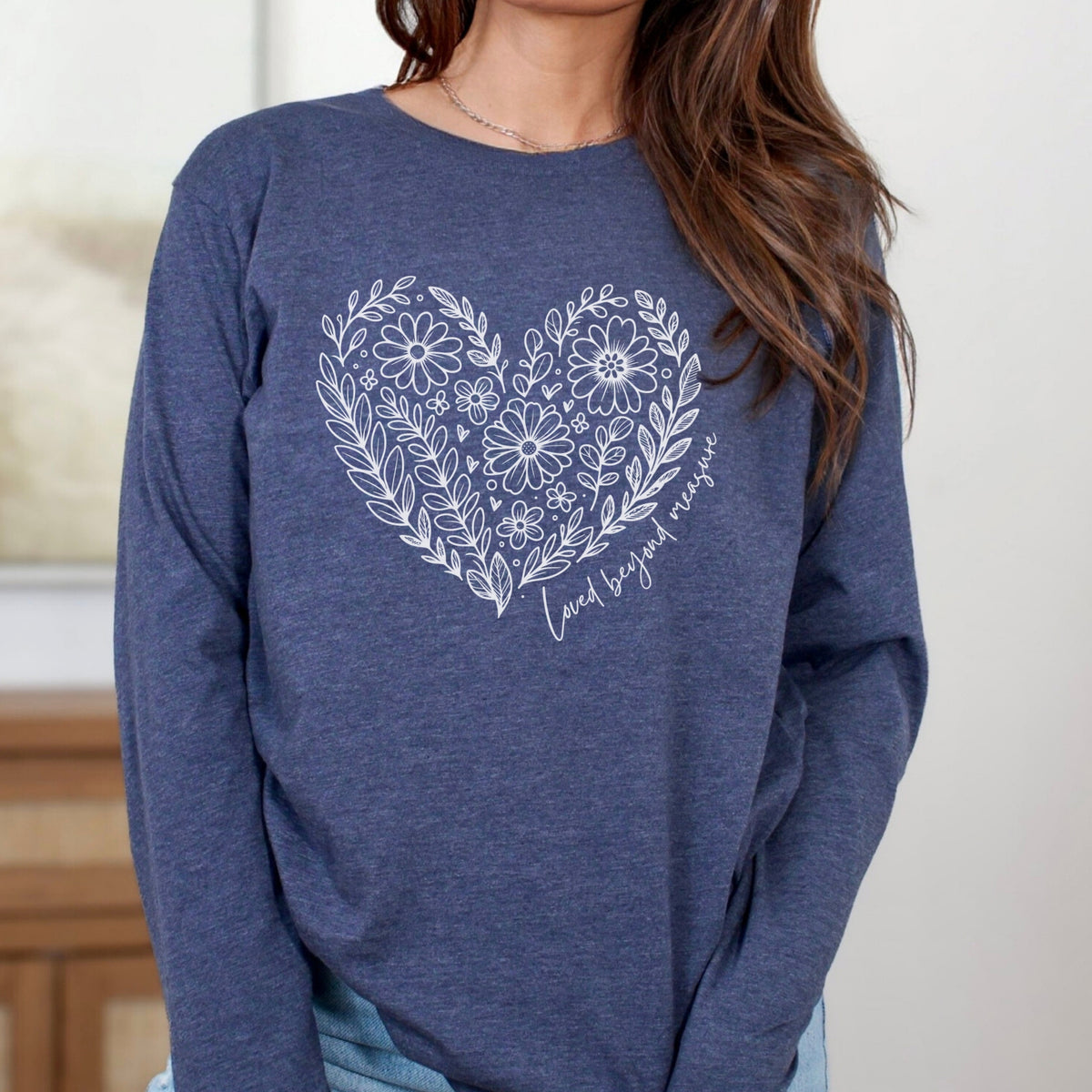 Blue long sleeve shirt with a floral heart design on a neutral background