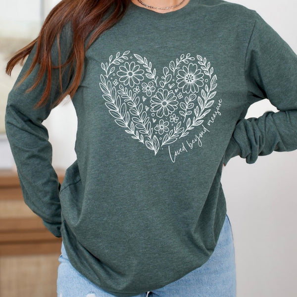 Green long sleeve shirt with floral heart design and text worn by a person.