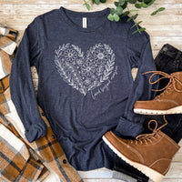 Navy blue long-sleeve shirt with floral heart design on a wooden surface with boots and plaid fabric.