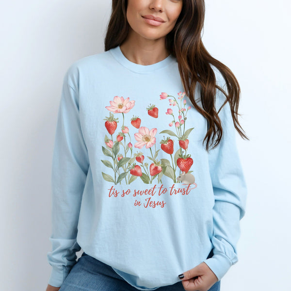 Light blue long sleeve tee with strawberry and flower design and text, worn by a person.