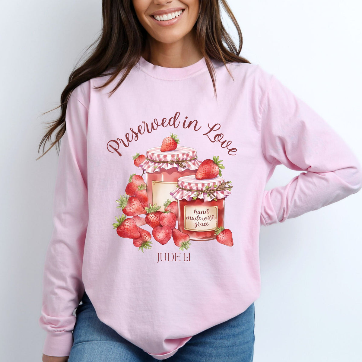 Person wearing a pink sweatshirt with strawberry design and text