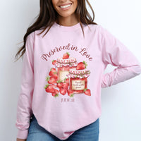 Person wearing a pink sweatshirt with strawberry design and text