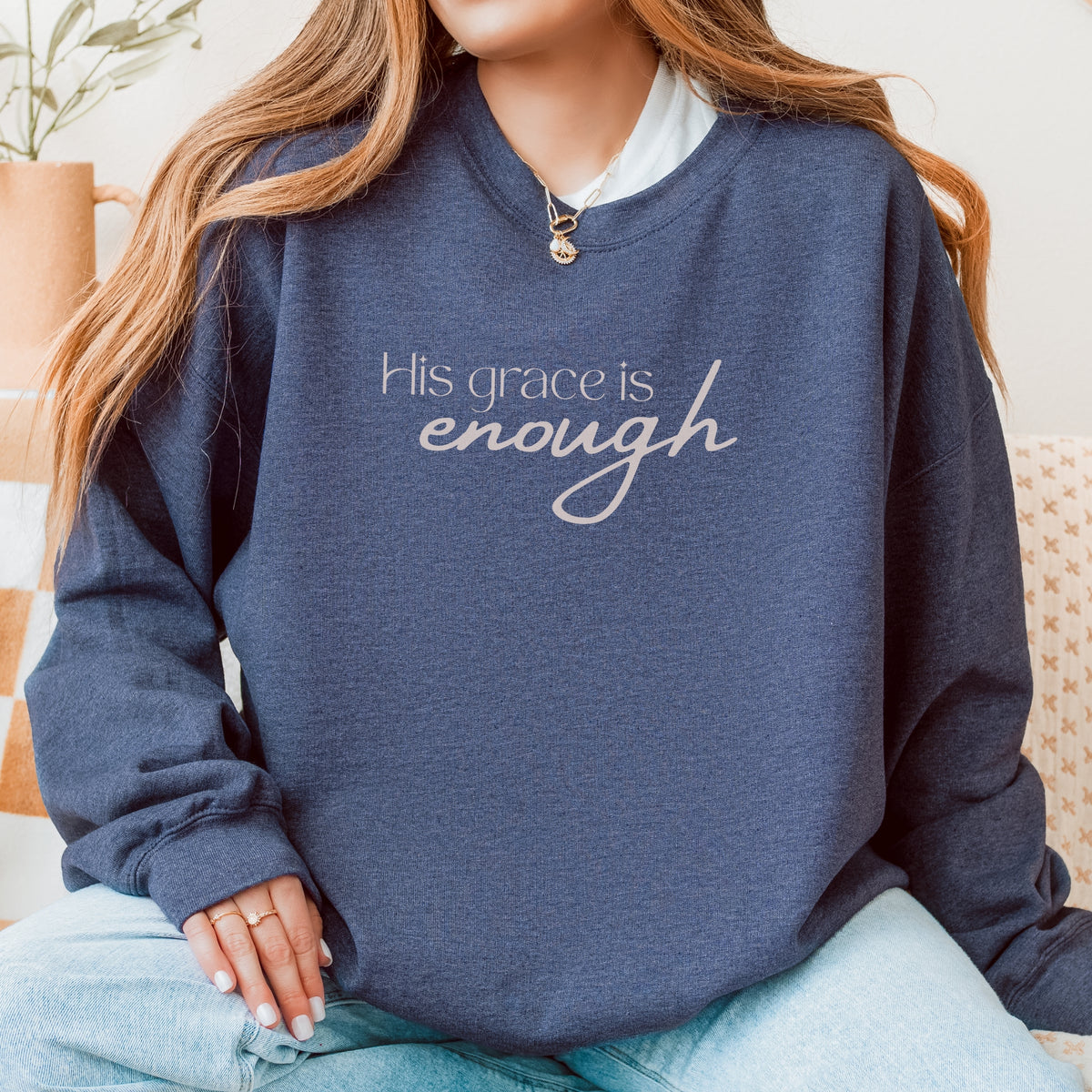 Person wearing a navy blue sweatshirt with 'His grace is enough' text.