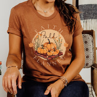 Person wearing an orange t-shirt with 'Faith, Fall, Flannel' design featuring pumpkins.