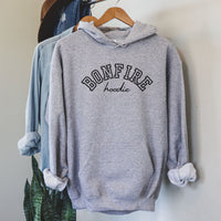 Gray hoodie with 'BONFIRE hoodie' text on a hanger against a neutral wall.