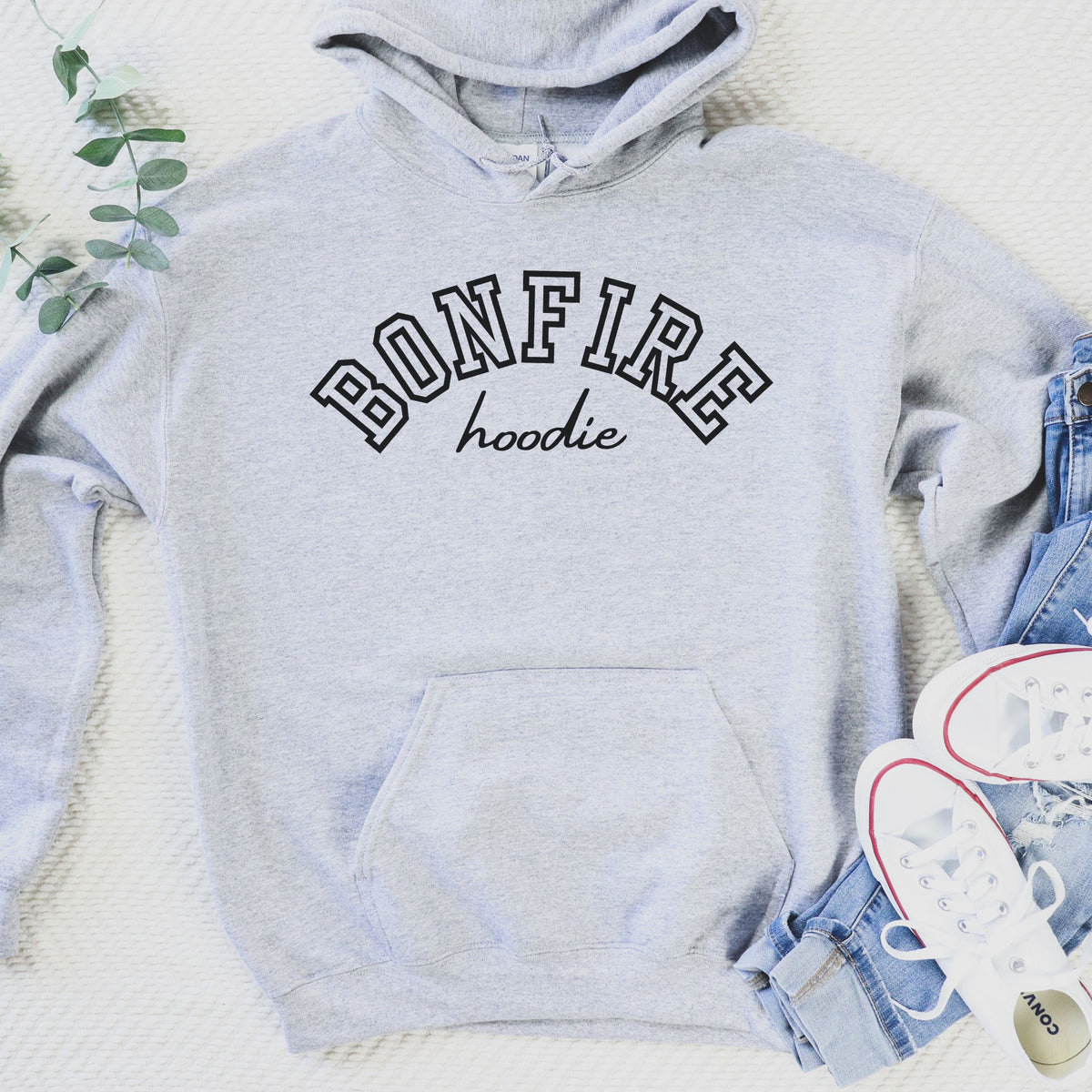 Gray hoodie with 'BONFIRE hoodie' text, denim shorts, and white sneakers on a light background