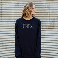Person wearing a navy sweatshirt with 'shine like Jesus' text against a corrugated metal background