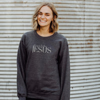 Person wearing a dark gray sweatshirt with 'shine like Jesus' text against a corrugated metal background