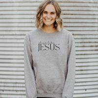 Person wearing a gray sweatshirt with 'shine like JESUS' text against a corrugated metal background