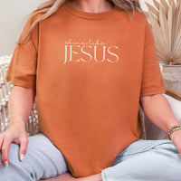 Person wearing an orange t-shirt with 'shine like Jesus' text.