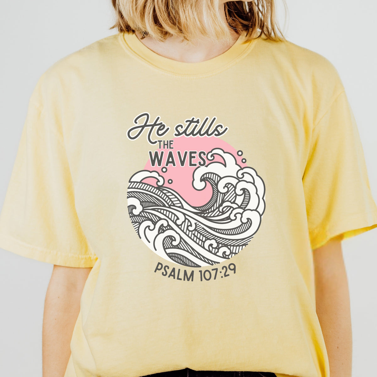 Yellow t-shirt with wave design and text on a plain background
