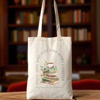 Tote bag with book-themed design and text on a wooden table with a bookshelf background