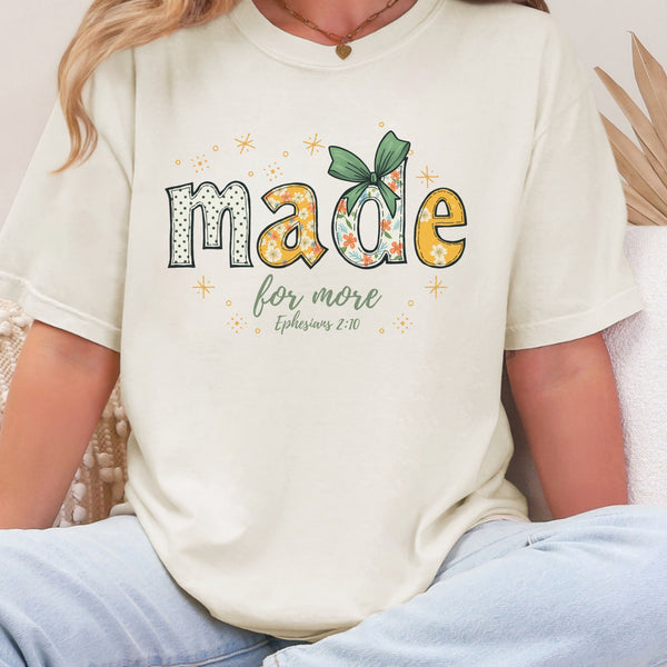 Person wearing an ivory t-shirt with 'made for more' text and design.