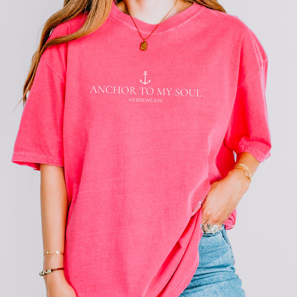 Person wearing a pink t-shirt with 'Anchor to My Soul' text on a plain background