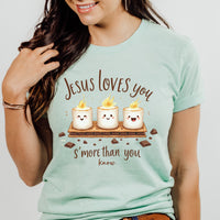 Person wearing a light blue t-shirt with a graphic and text about Jesus loves you 's'more' than you know.