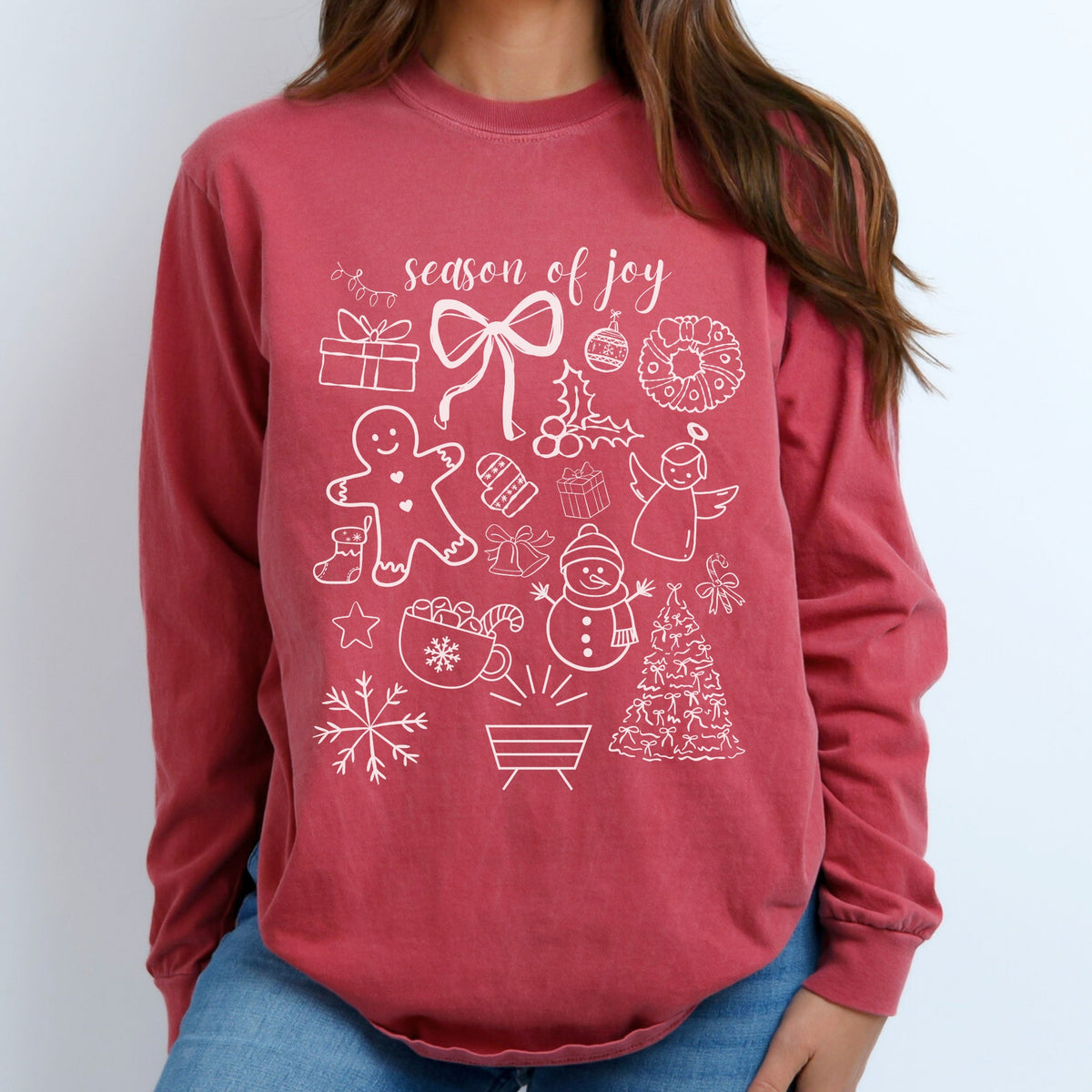 Red long-sleeve shirt with white Christmas-themed graphics on a plain background