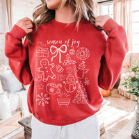 Red sweatshirt with Christmas-themed designs and text 'season of joy' worn by a person in a home setting.