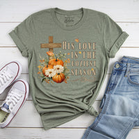 Green t-shirt with pumpkin and cross design on a wooden surface with shoes and jeans.