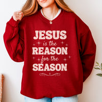 Red sweatshirt with 'Jesus is the Reason for the Season' text worn by a person.