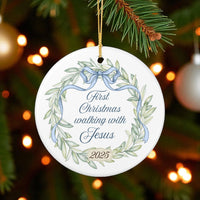 Decorative Christmas ornament with wreath and text on a tree with lights in the background