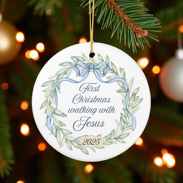 Decorative Christmas ornament with wreath and text on a tree with lights in the background