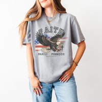Person wearing a gray t-shirt with an eagle graphic and text on a white background