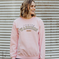 Woman wearing a pink sweatshirt with 'Raising Warriors for Christ' text against a corrugated metal background