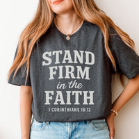 Person wearing a gray t-shirt with 'Stand Firm in the Faith' text