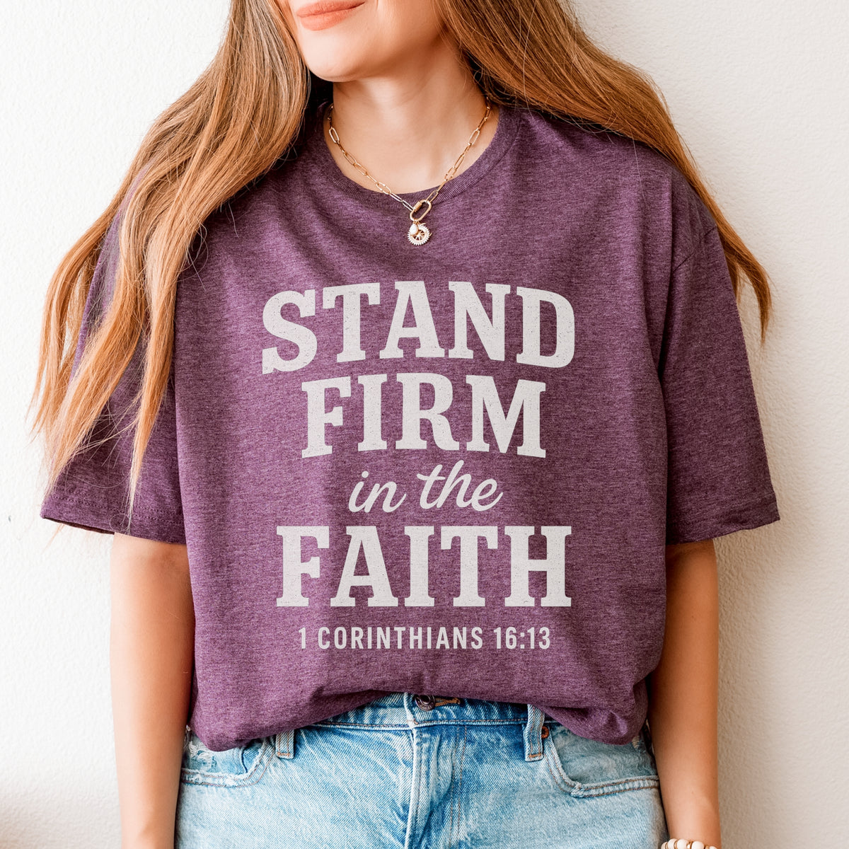 Person wearing a maroon t-shirt with 'Stand Firm in the Faith' text