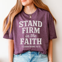 Person wearing a maroon t-shirt with 'Stand Firm in the Faith' text