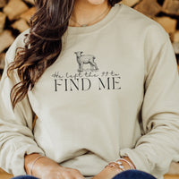 Person wearing a beige sweatshirt with a graphic and text