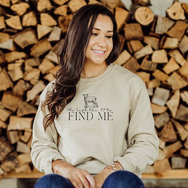 Woman wearing a beige sweatshirt with text and a graphic, sitting in front of stacked wood.