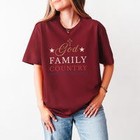 Red t-shirt with 'God Family Country' text worn by a person on a white background