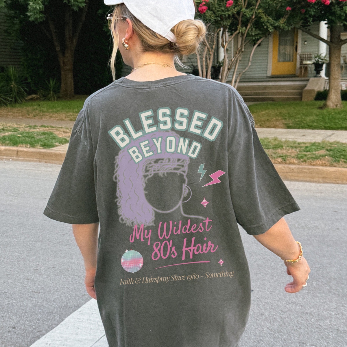 Person wearing a t-shirt with 'Blessed Beyond My Wildest 80's Hair' design outdoors.