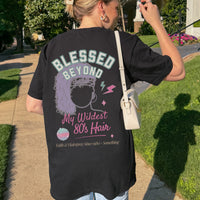 Person wearing a black t-shirt with a graphic design and text, standing outdoors.