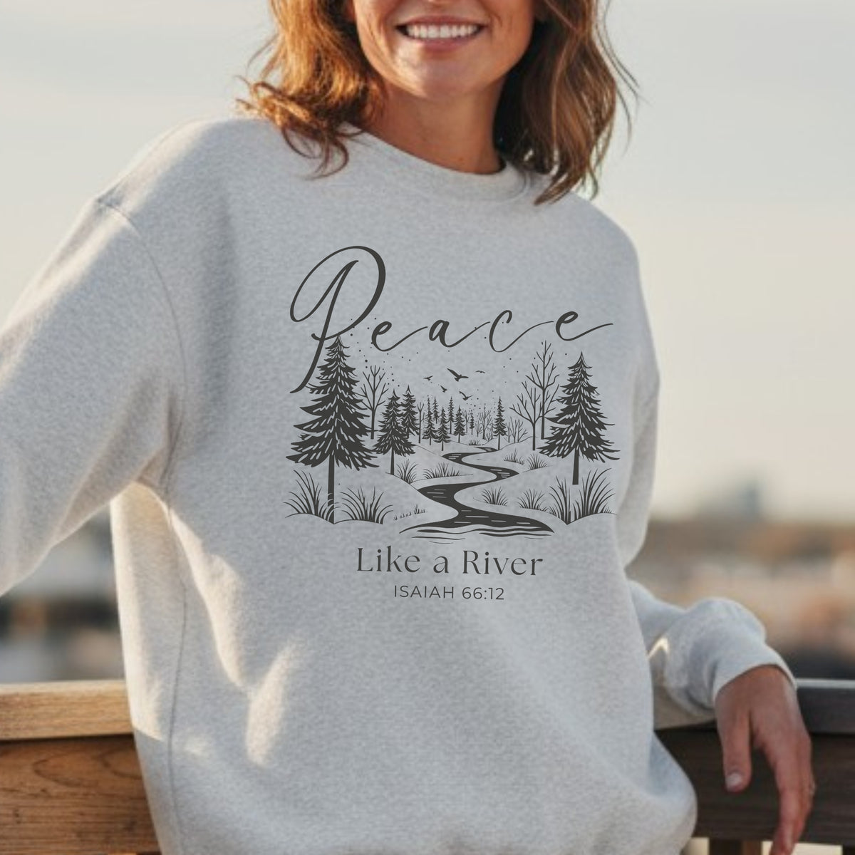 Person wearing a gray sweatshirt with a nature-themed design and text.